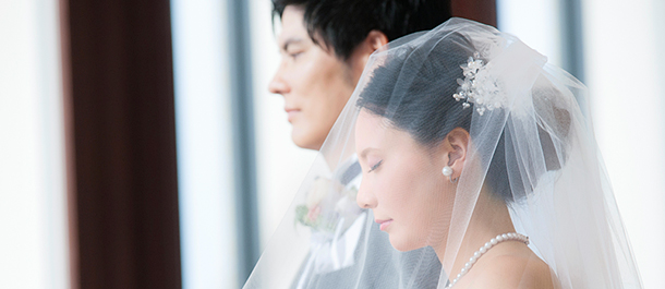 結婚式で新郎の隣でヴェールを被っている山下弘子さんの横顔