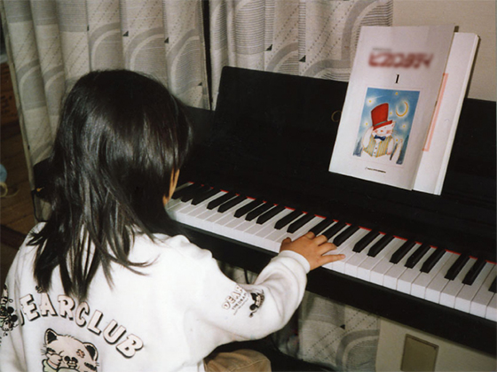 ピアノに向かう、子どものころのより子さん